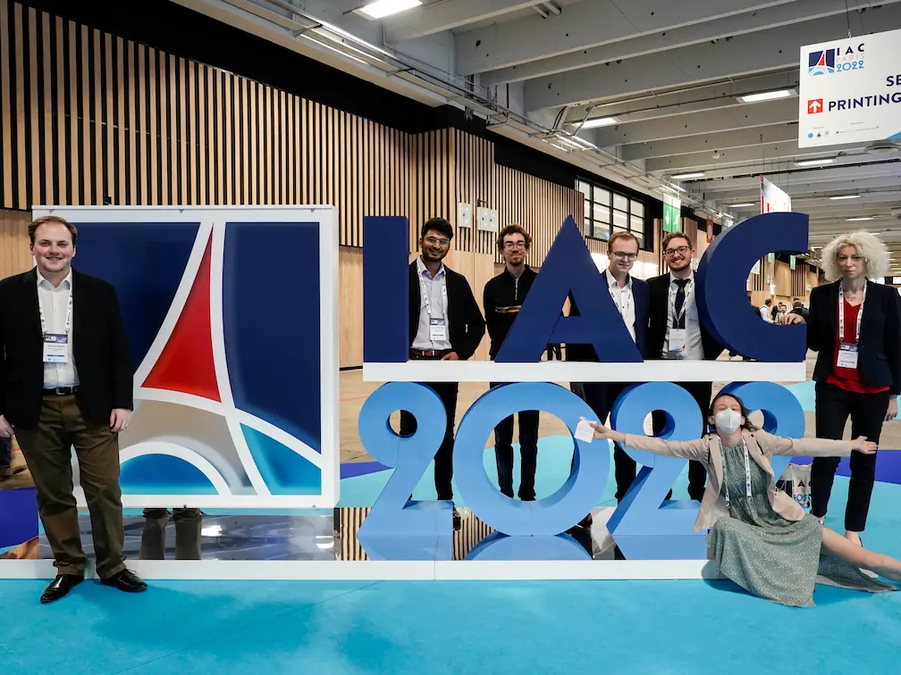 Conex members standing around an IAC 2022 sign