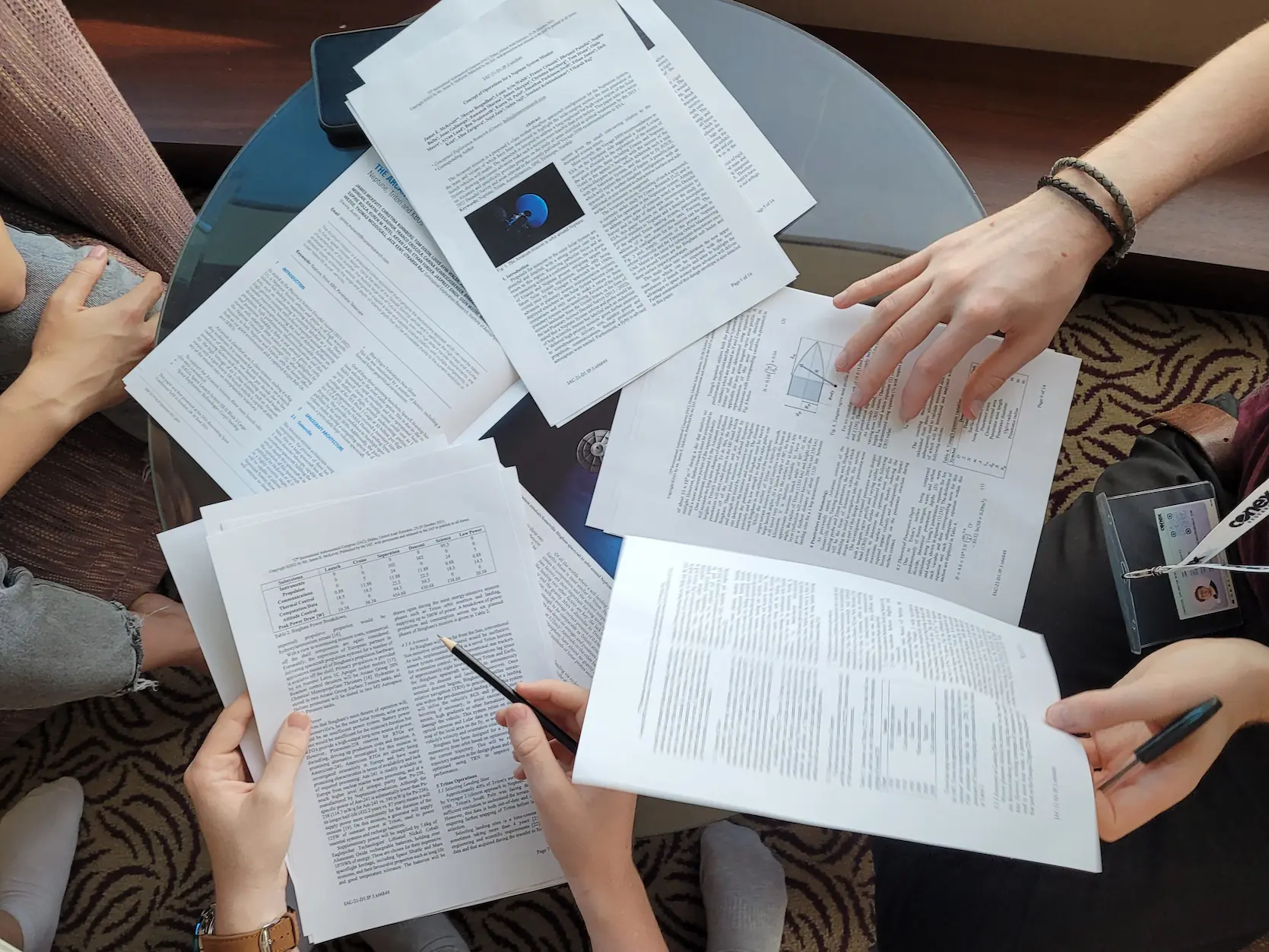 Overhead photo of team members reviewing various Conex papers